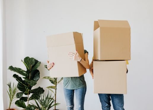couple-carrying-cardboard-boxes-in-living-room