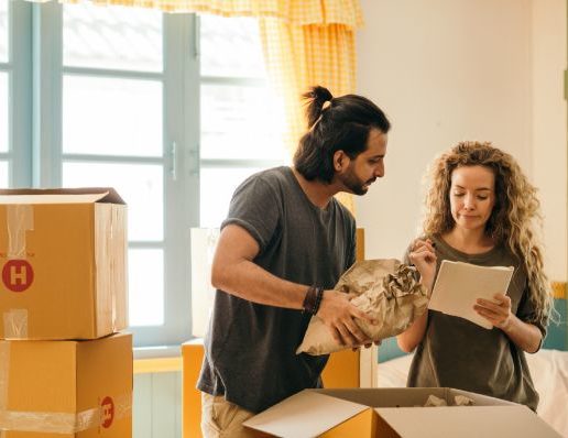 happy-couple-unpacking-boxes-in-new-home
