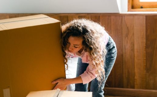 young-woman-unpacking-boxes-in-light-apartment